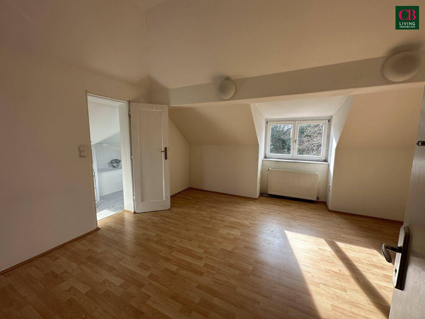 Helles, unmöbliertes Schlafzimmer im Dachgeschoss mit Laminatboden und Dachschräge.