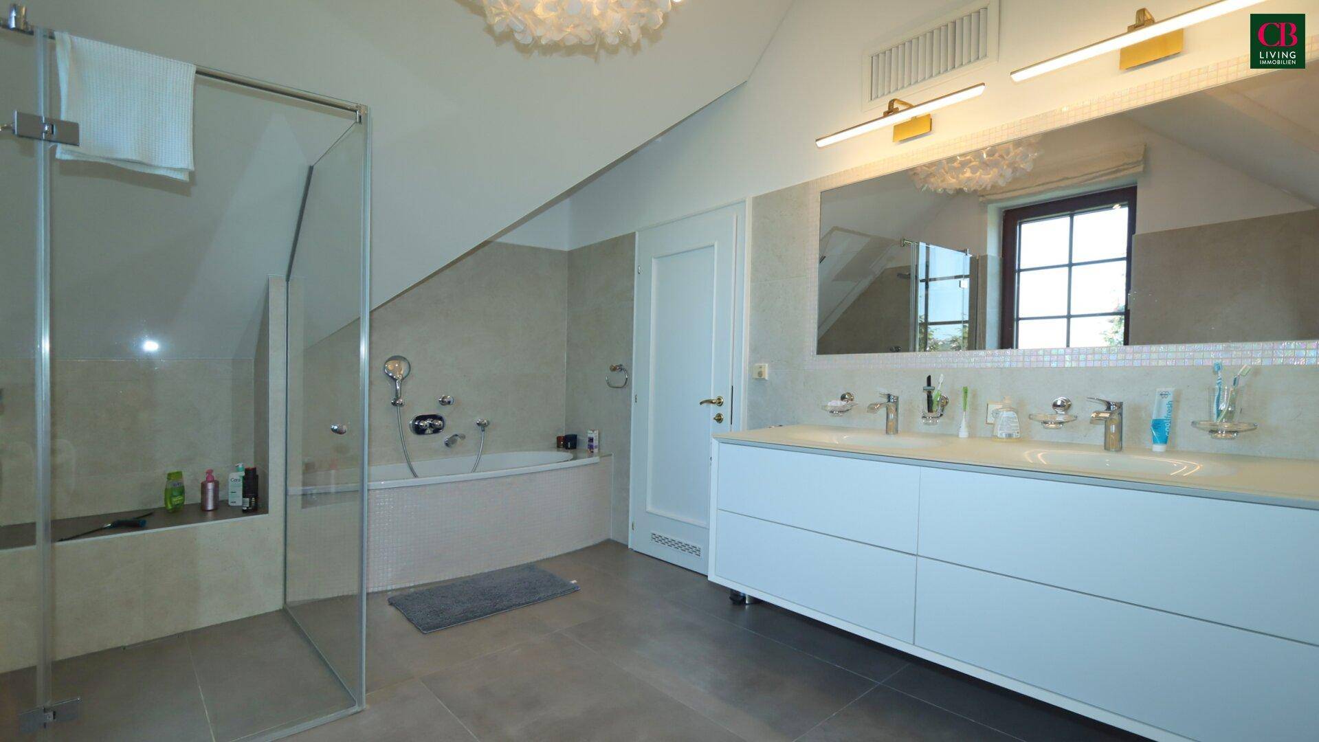 Modernes Badezimmer mit begehbarer Dusche, Badewanne und Doppelwaschbecken unter Dachschräge.