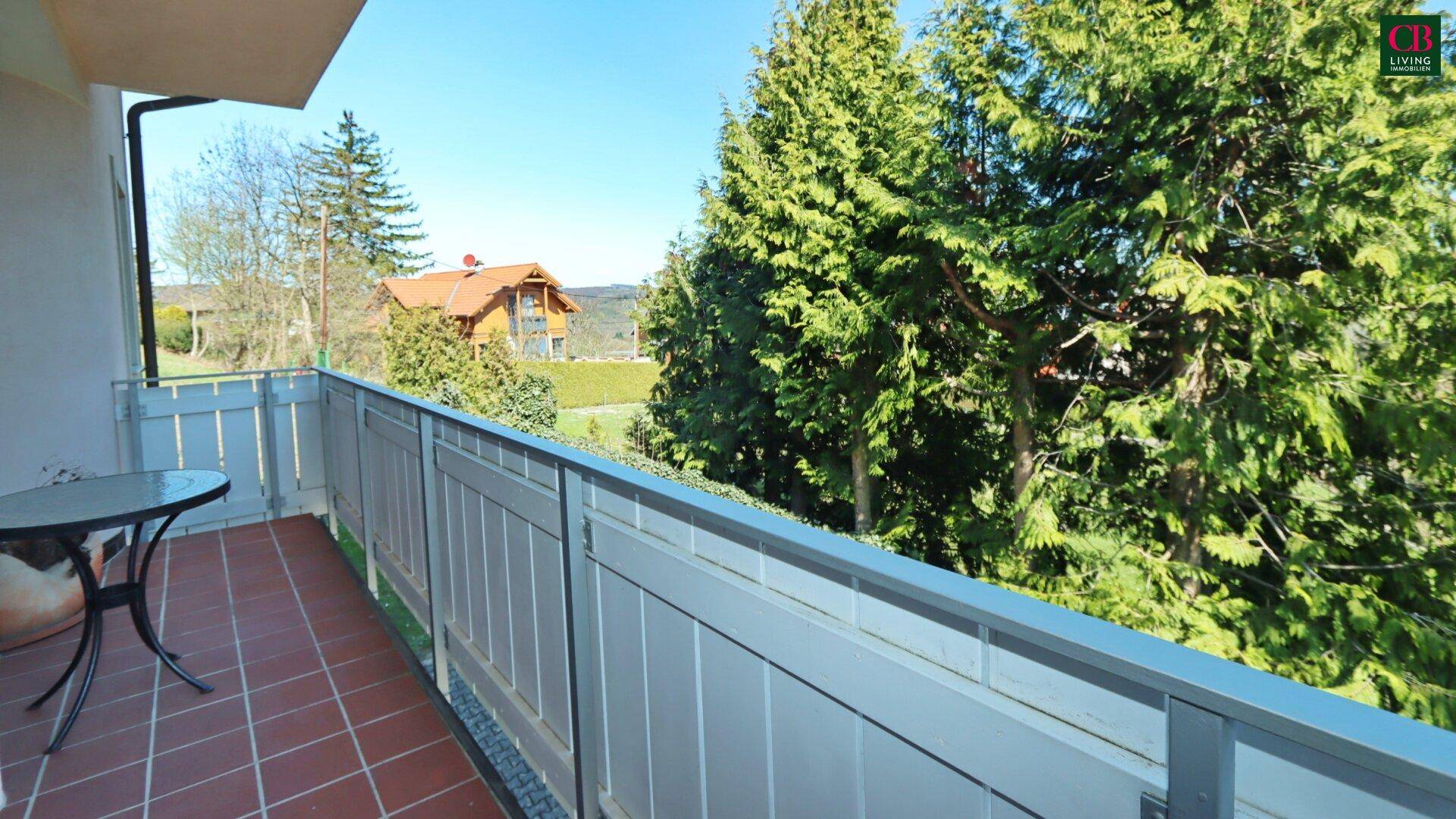 Kleiner Balkon mit Terrakottafliesen und Blick ins Grüne und auf die Umgebung.