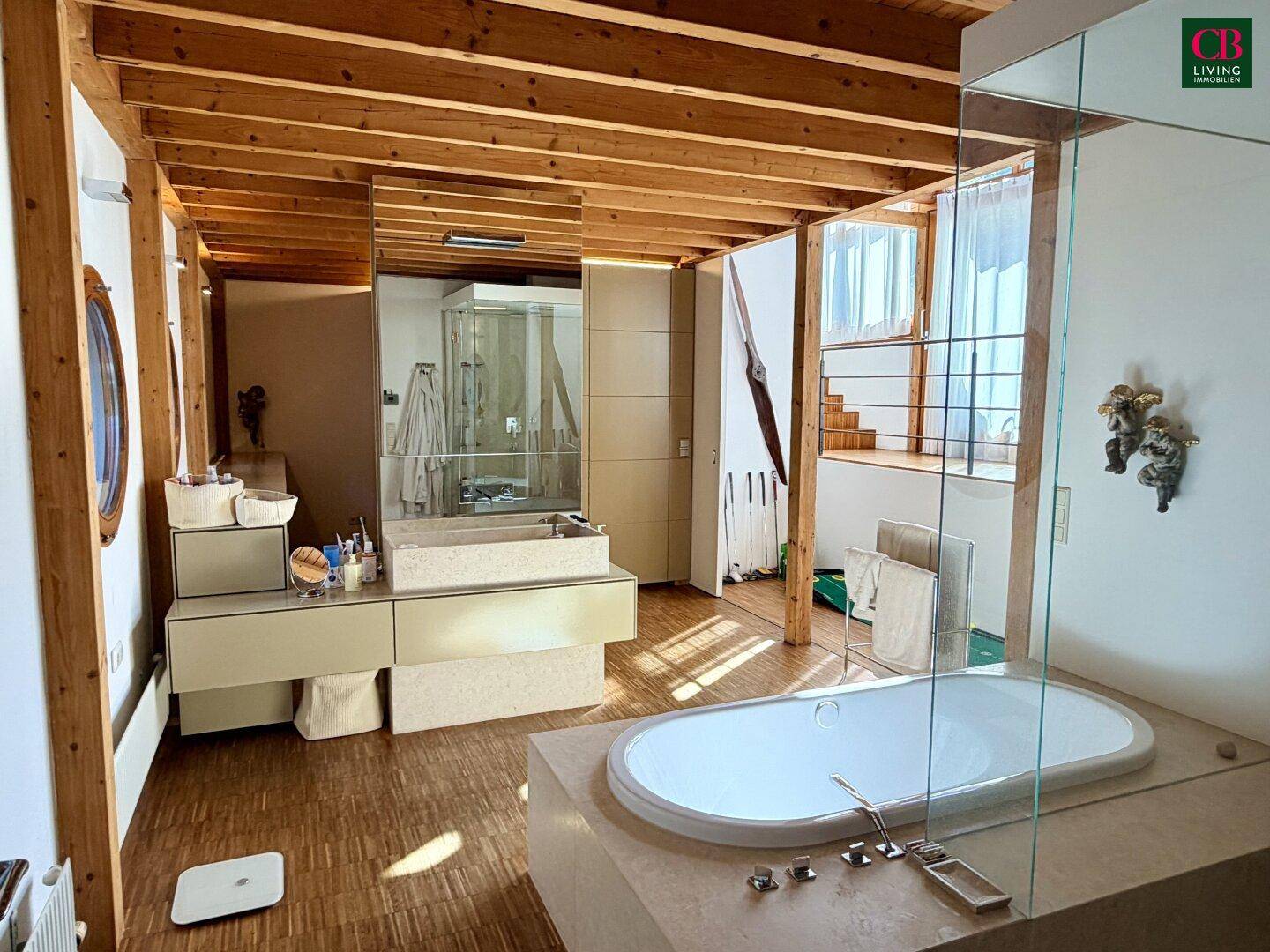 Modernes Badezimmer mit eingelassener Badewanne, Doppelwaschbecken und Holzbalkendecke.