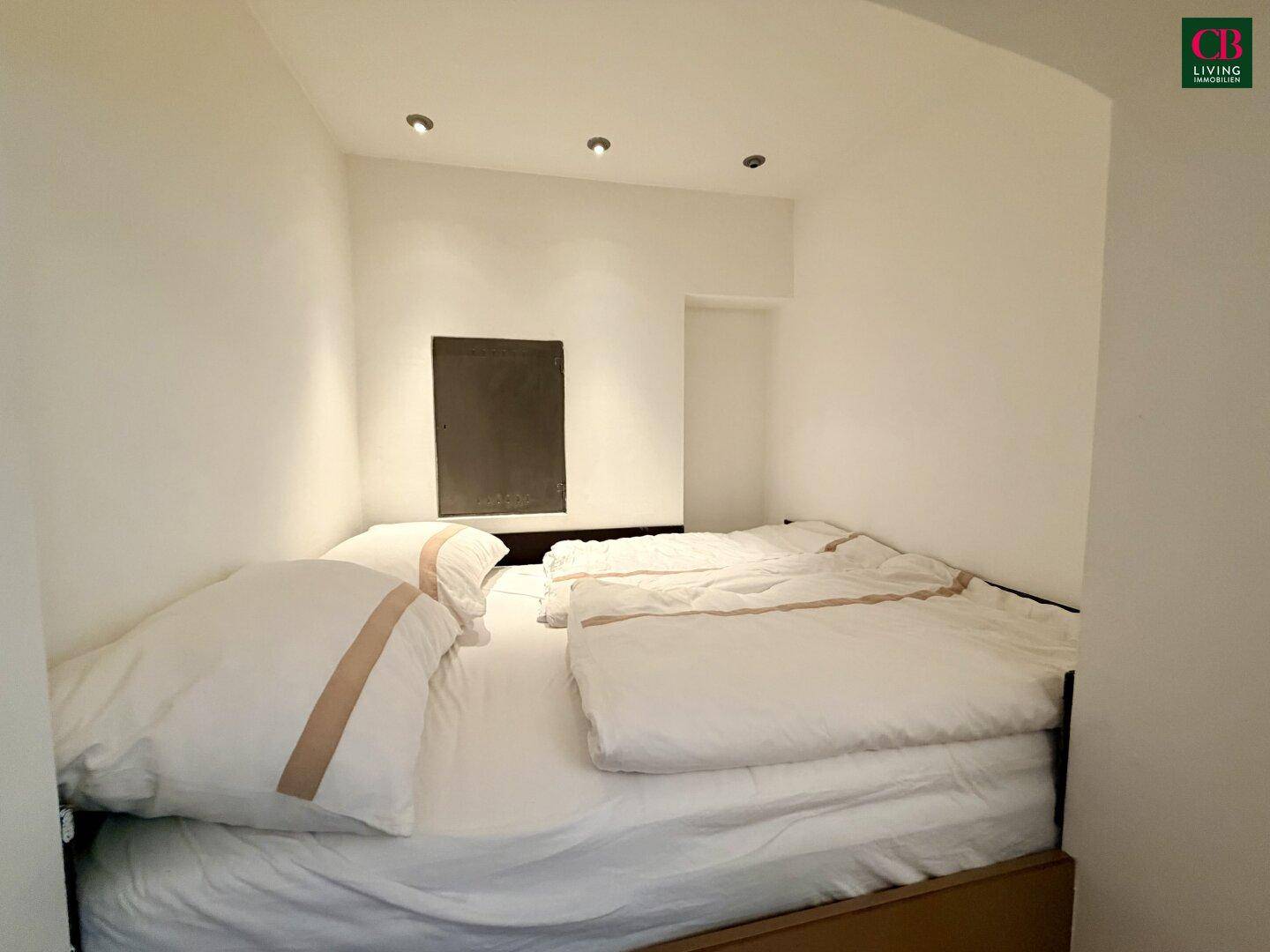 Gemütlicher Schlafbereich in einer Nische mit integriertem Bett und indirekter Beleuchtung.