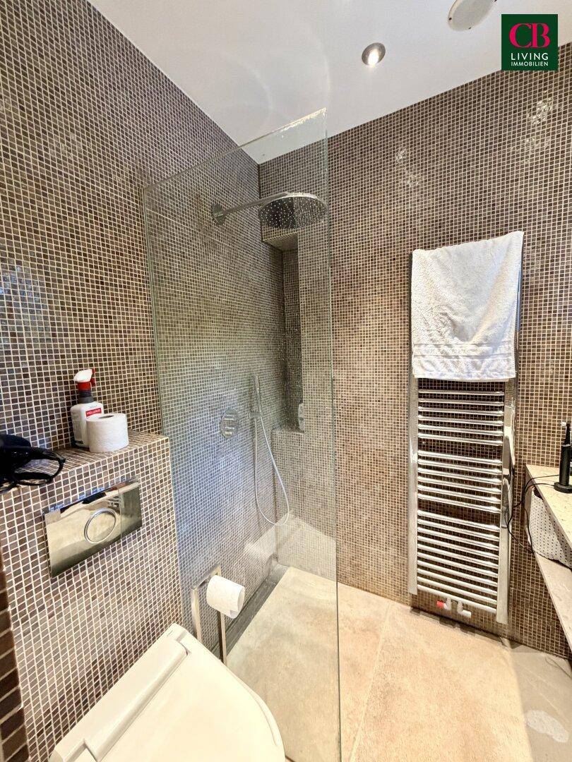 Modernes Badezimmer mit begehbarer Dusche, Mosaikfliesen und beheiztem Handtuchhalter.