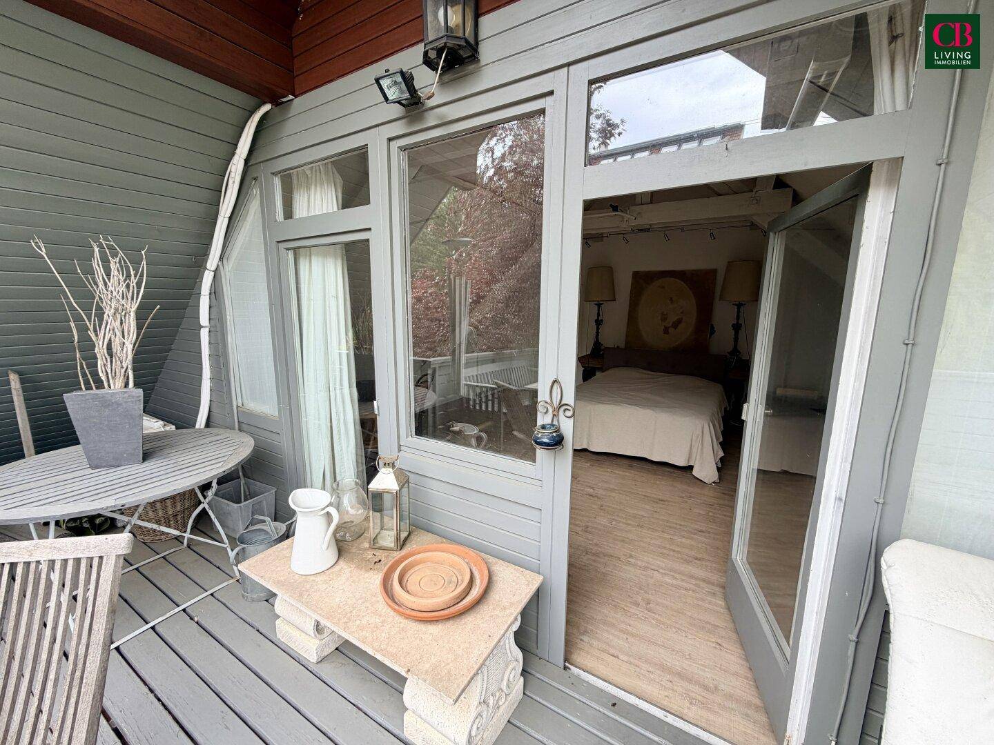 Kleiner Balkon mit Holzboden und Sitzgelegenheiten, zugänglich vom Schlafzimmer im Dachgeschoss.