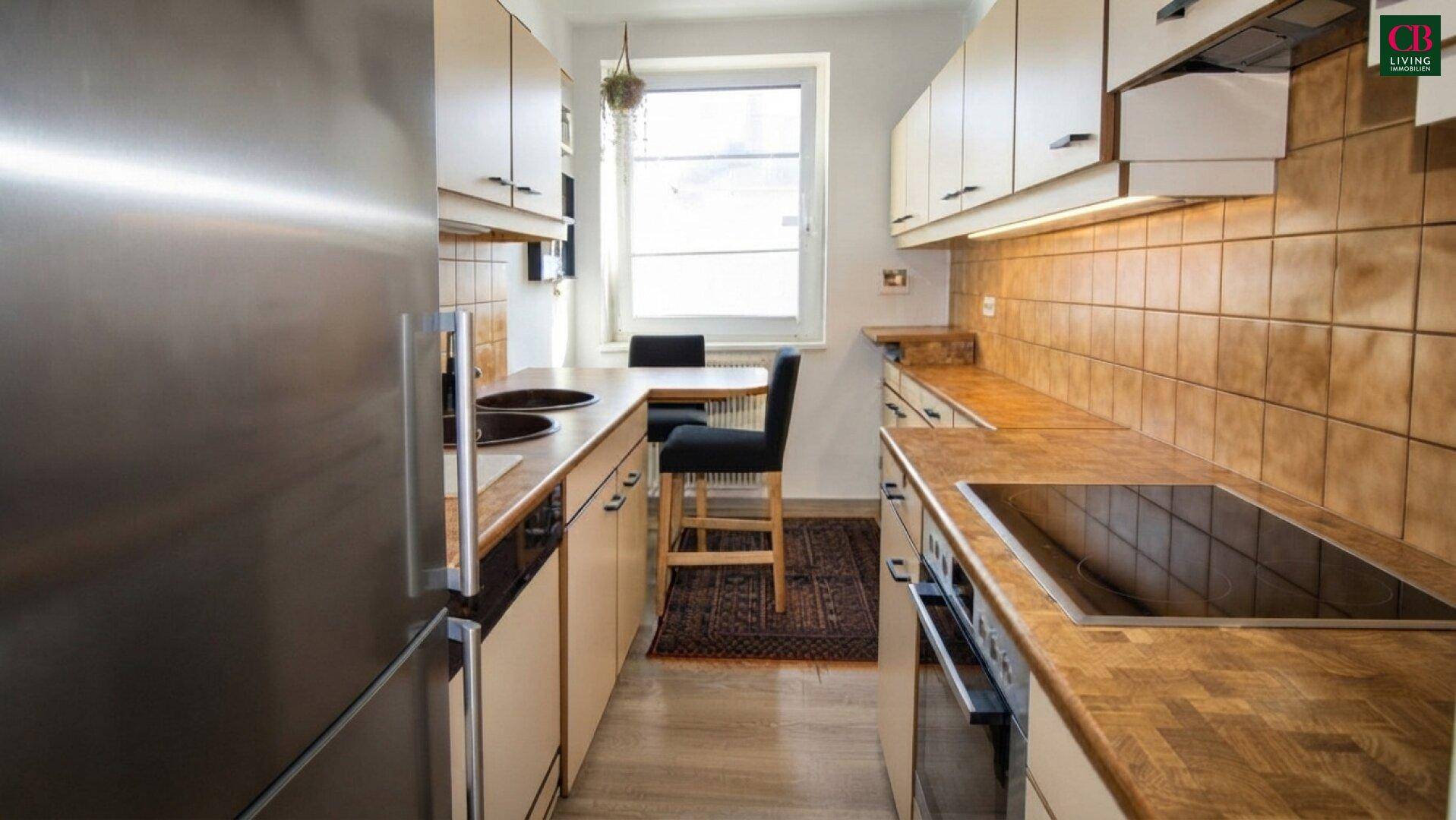 Funktionale Küche mit Holz-Arbeitsplatten, hellen Schränken, Induktionskochfeld und Essbereich.
