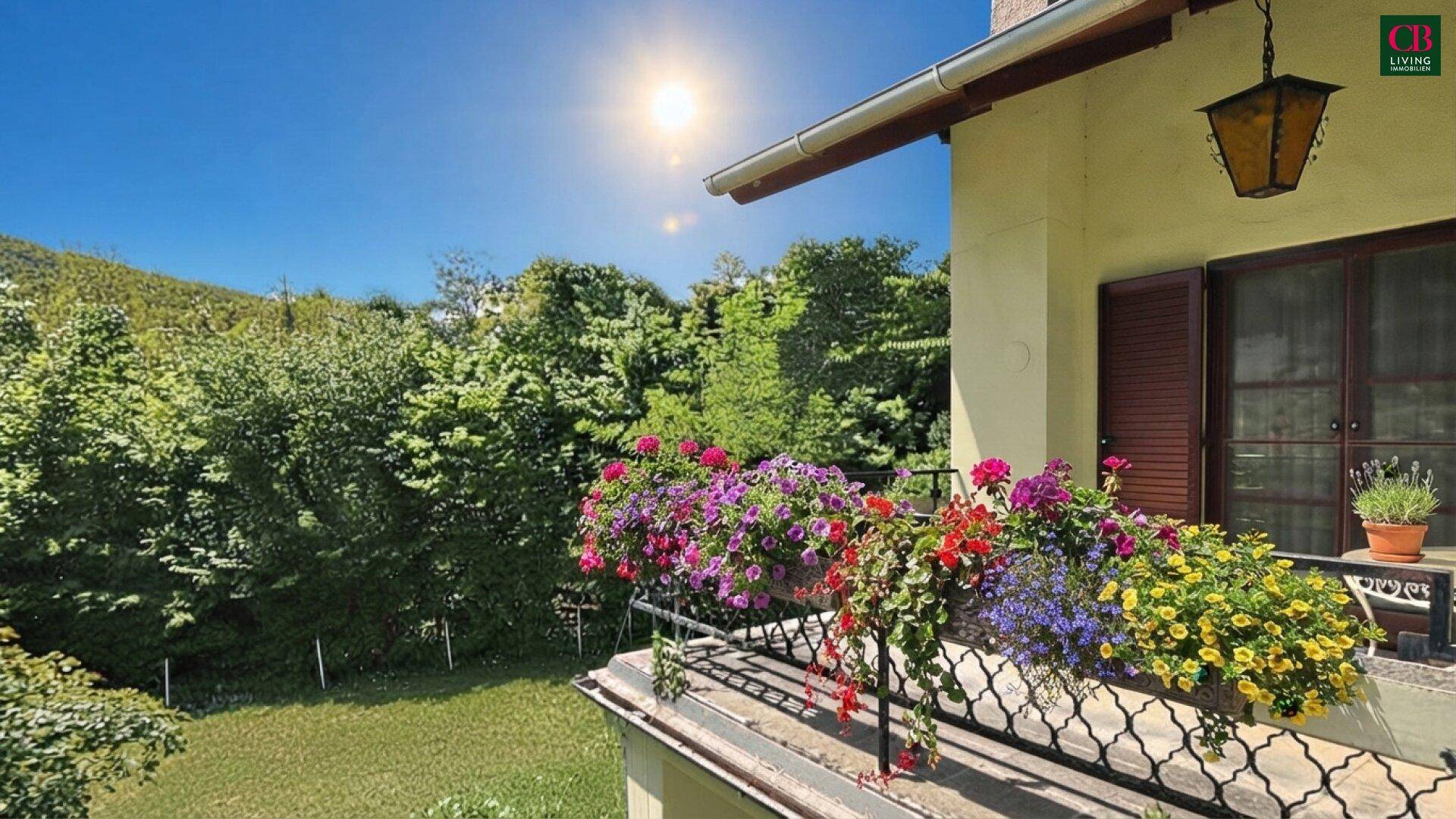 Sonniger Balkon mit Blumenkästen und weitem Blick ins Grüne.