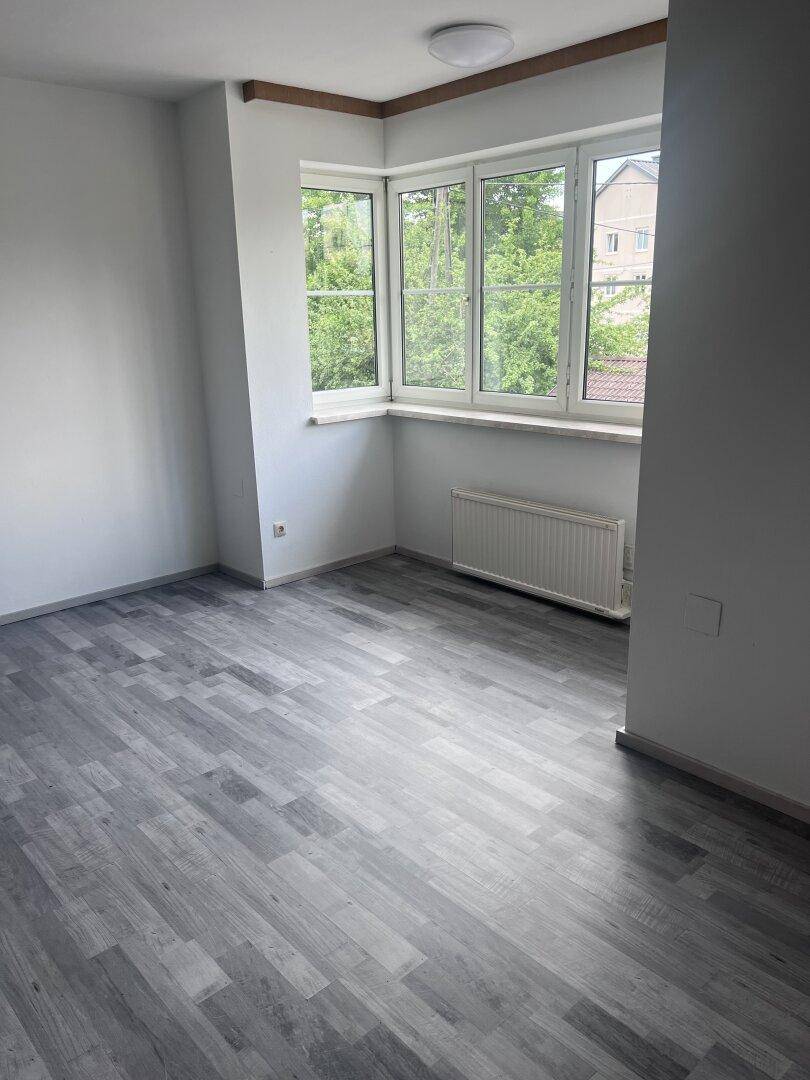 Eckbüro mit großen Fenstern, die viel Tageslicht bieten, und grauem Laminatboden.