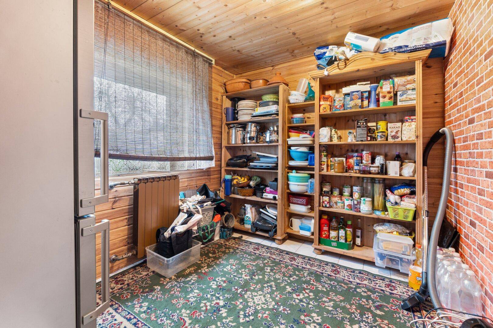 Geräumige Speisekammer mit Holzregalen und Holzvertäfelung, ideal für Vorräte.