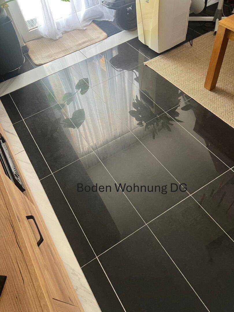 Dunkler, glänzender Fliesenboden in einem Wohnbereich im Dachgeschoss.