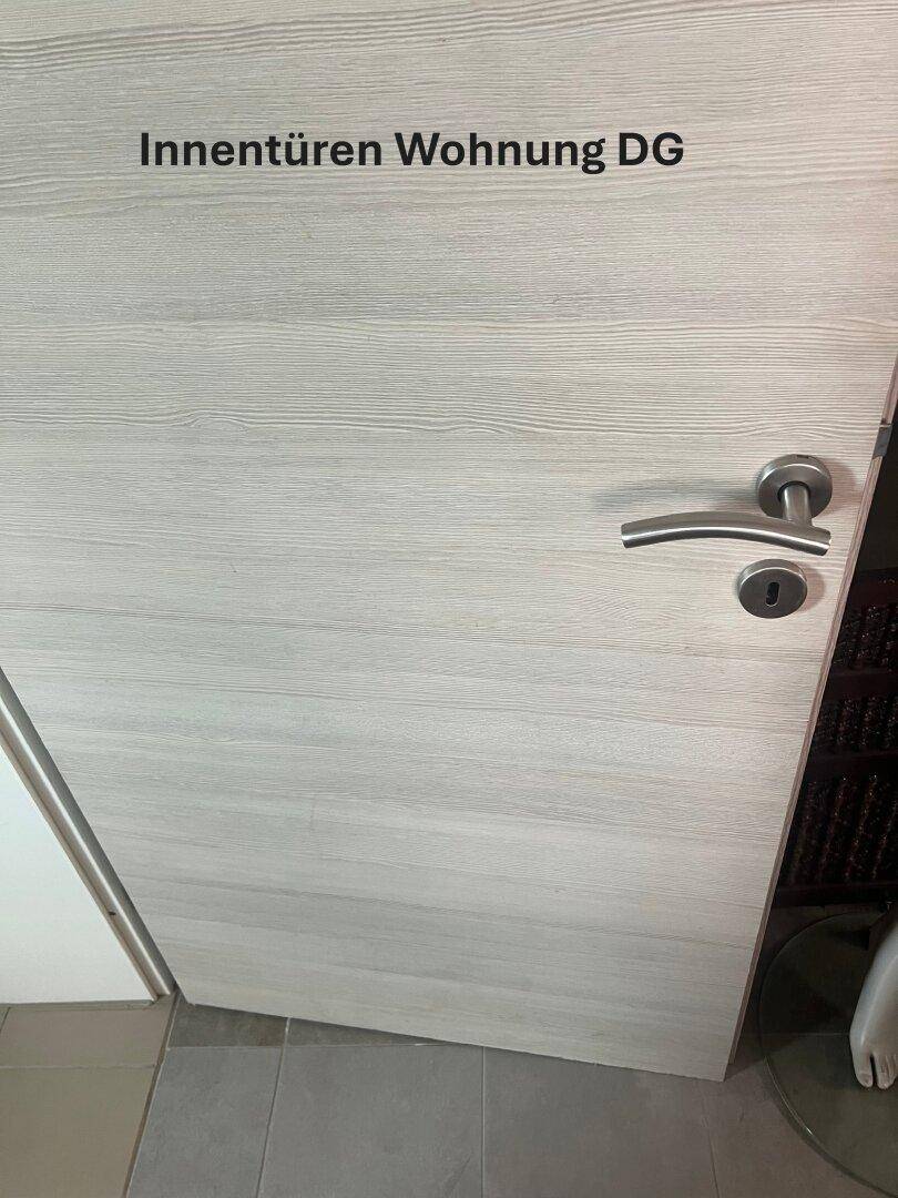 Helle Holztür mit moderner Klinke in einer Wohnung im Dachgeschoss.