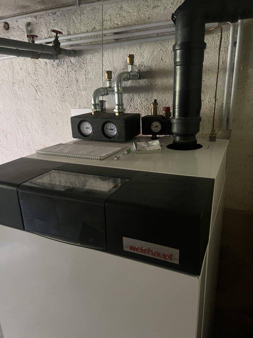 Heizkessel der Marke Weishaupt mit angeschlossenen Rohren im Technikraum.