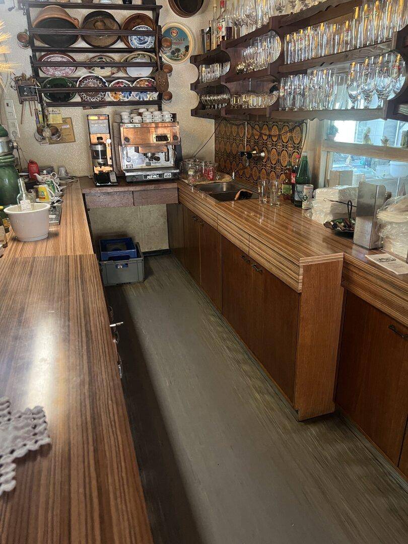 Bar- und Küchenbereich mit Holzarbeitsplatten, Spüle und Kaffeemaschine.