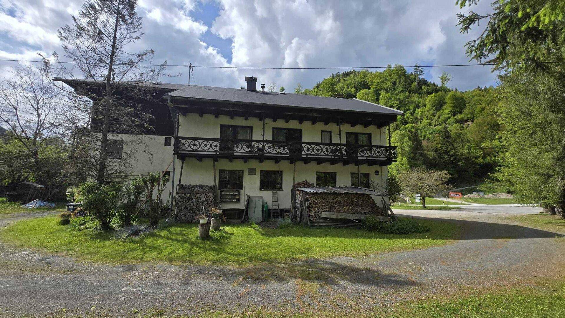 Alpenländisches Gebäude mit Balkonen und Holzfassade, eingebettet in die Berglandschaft.