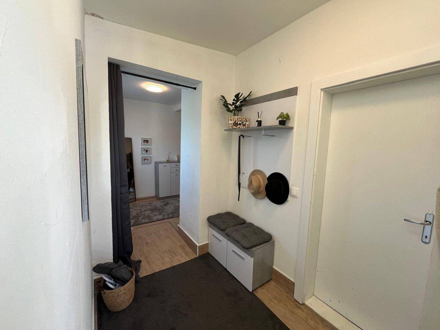 Eingangsbereich mit Garderobe und Sitzbank, der zu den weiteren Wohnbereichen führt.