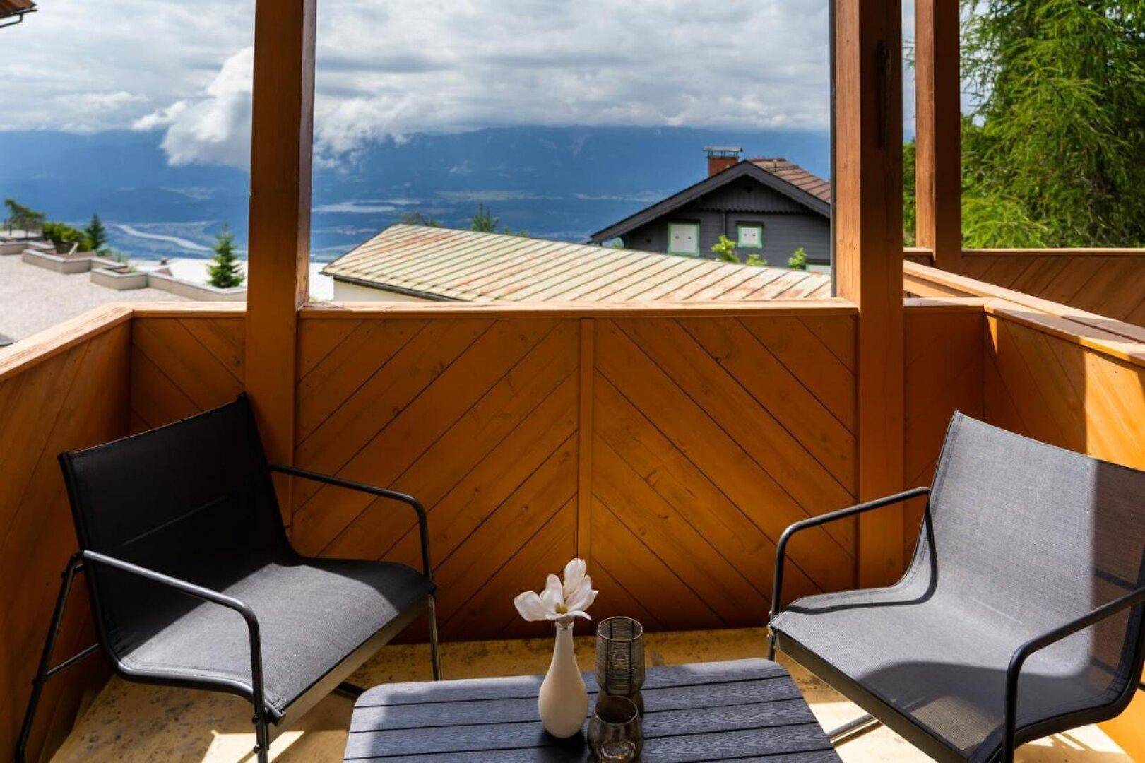 Gemütlicher Balkon mit Sitzgelegenheiten und Panoramablick auf die umliegende Berglandschaft.