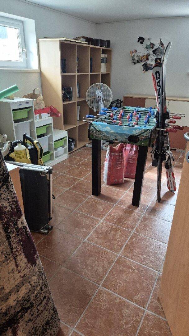 Freizeitraum mit Tischfußball, Regal und Sportgeräten, ideal für Unterhaltung und Hobbys.