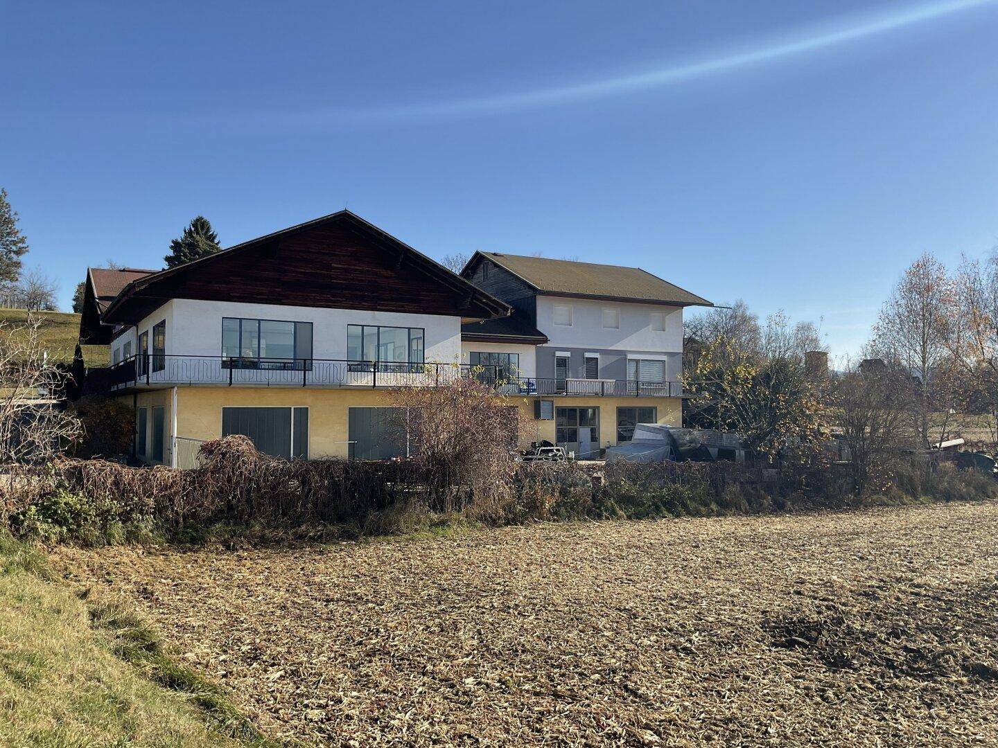 Weitläufige Ansicht der Gewerbegebäude mit angrenzendem Feld und Blick in die Landschaft.