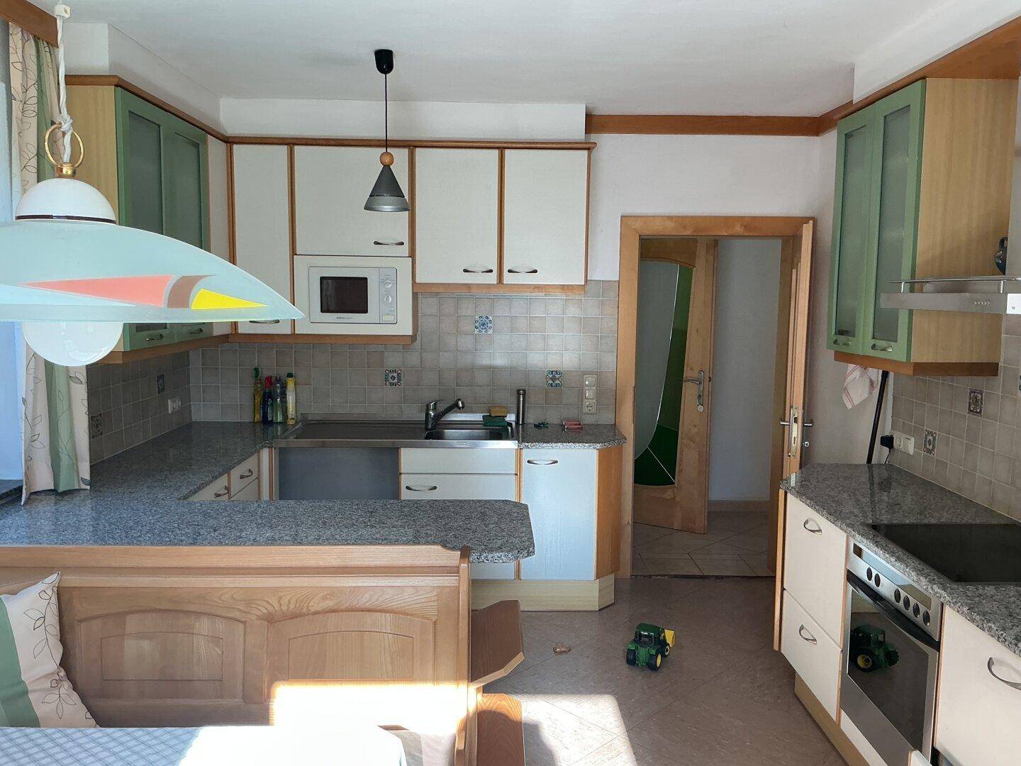 Gemütliche Küche im Landhausstil mit hellgrünen Akzenten, Holzelementen und Granitarbeitsplatten.