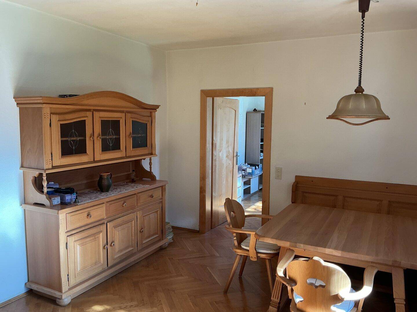 Geräumiger Essbereich mit klassischem Holzbuffet und Zugang zu einem weiteren Zimmer.