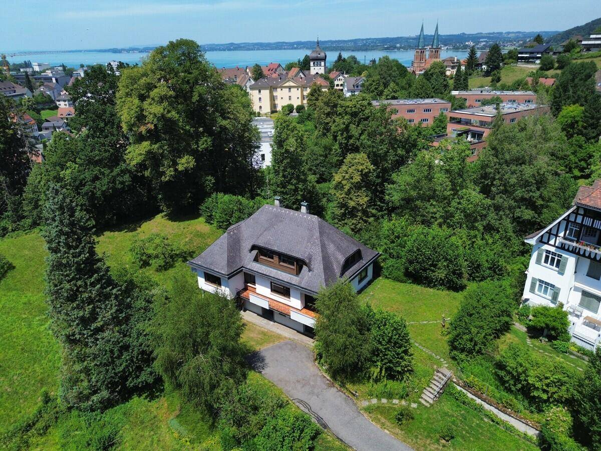 Luftaufnahme des Anwesens mit See im Hintergrund und umgeben von viel Grün.