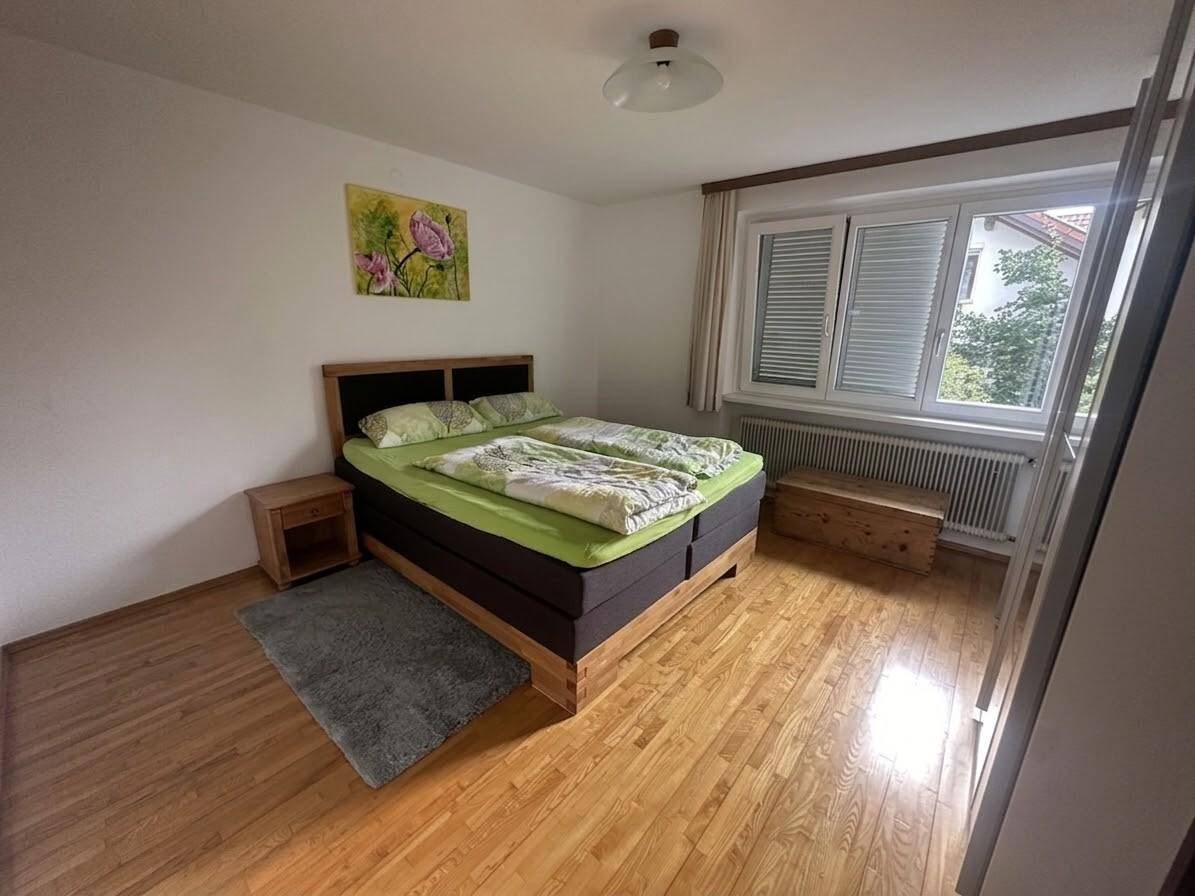 Schlafzimmer mit Doppelbett, Nachttischen und hellem Parkettboden.