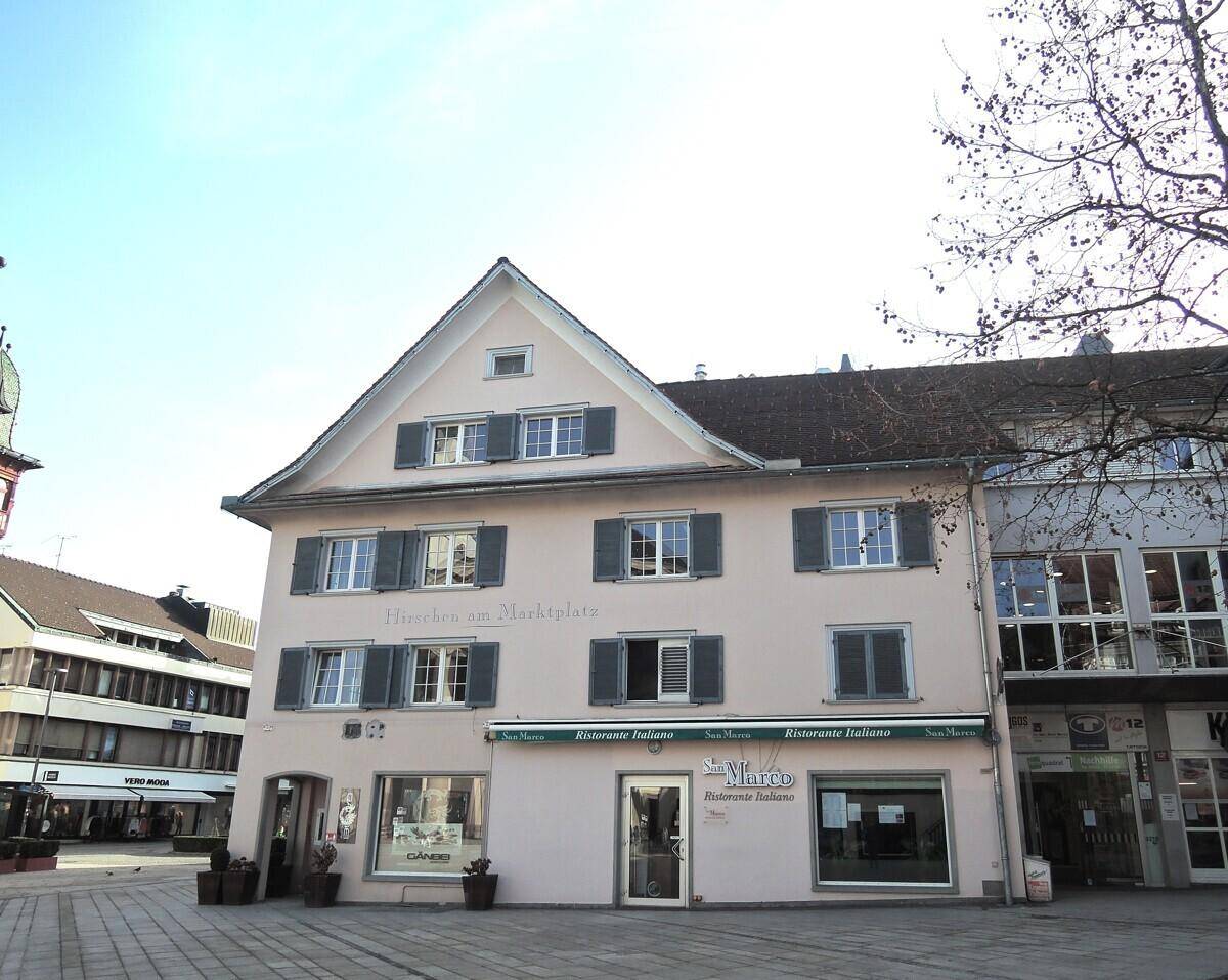 Historisches Gebäude mit Restaurant im Erdgeschoss und Wohnungen darüber am Marktplatz.