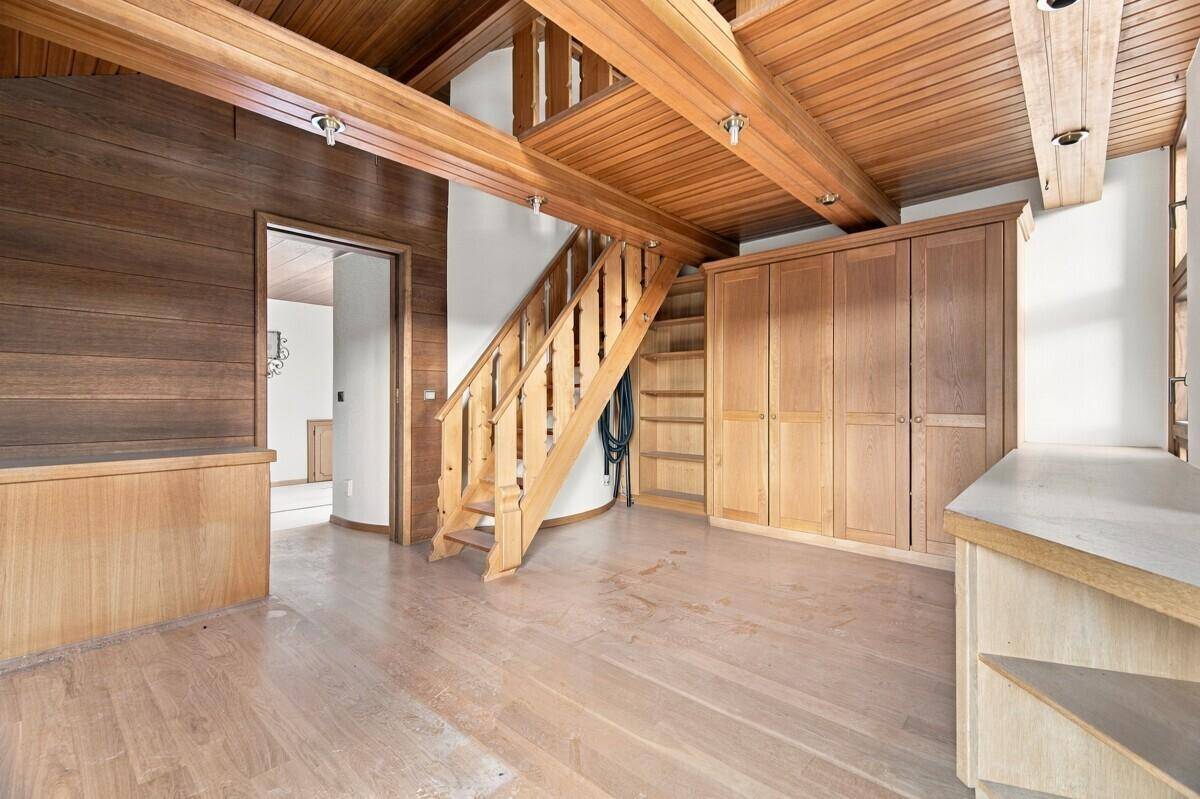 Heller Flurbereich mit Holzvertäfelung, offener Treppe und praktischen Einbauschränken für Stauraum.