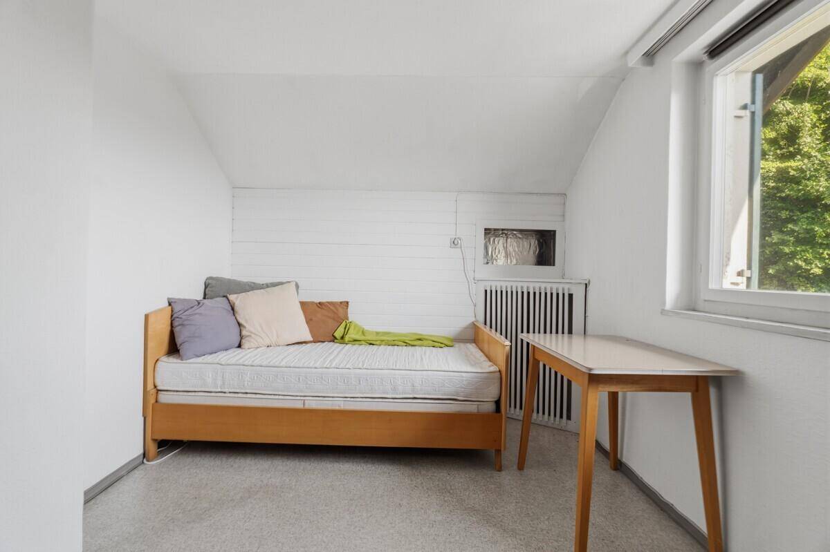 Gemütliches Schlafzimmer mit Tagesbett, Dachschräge und Fenster, das viel Licht spendet.