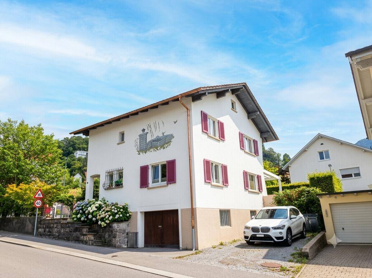 Ansicht des Hauses von der Straße mit Einfahrt, Garage und gepflegter Außenanlage.