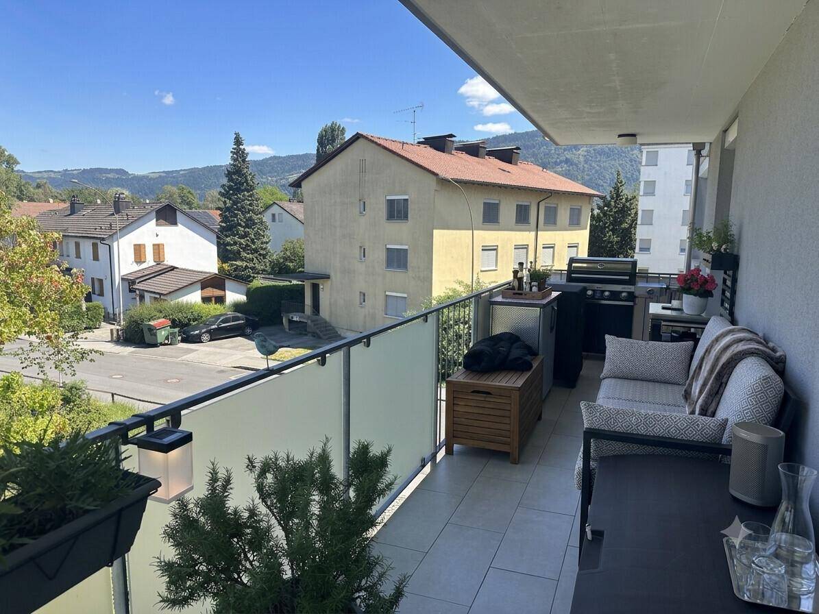 Großer Balkon mit Lounge-Möbeln und Grillbereich, bietet einen weiten Blick über die Nachbarschaft.