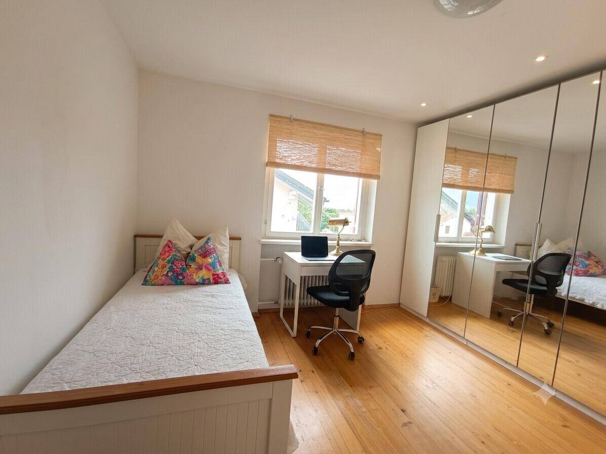 Helles Kinderzimmer mit Einzelbett, Schreibtisch und großem Spiegelschrank für viel Stauraum.