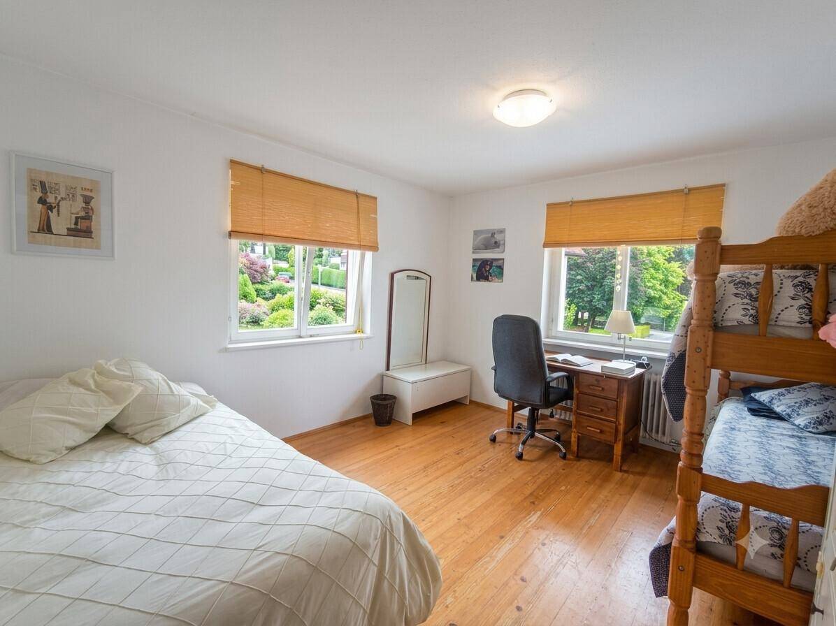 Kinderzimmer mit Einzelbett, Etagenbett, Schreibtisch und schönem Blick ins Grüne.