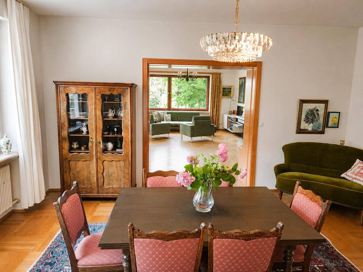 Klassischer Essbereich mit Holztisch und Stühlen, offen zum angrenzenden Wohnzimmer.