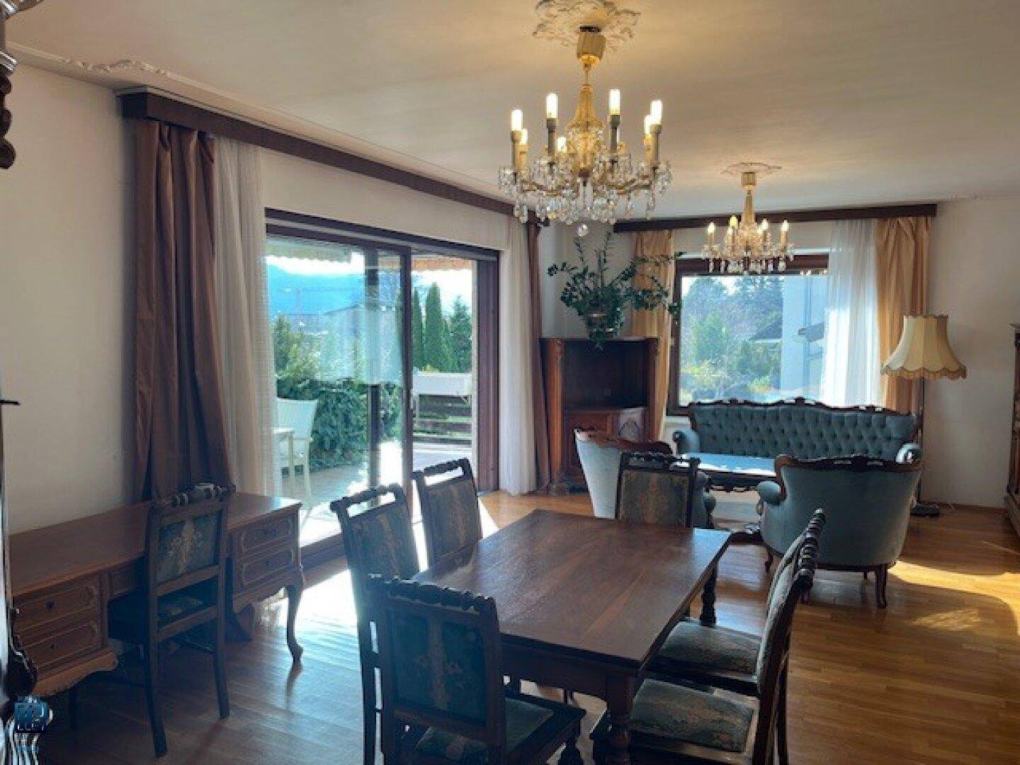 Heller Wohn- und Essbereich mit Holzboden, großen Fenstern und direktem Zugang zur Terrasse.