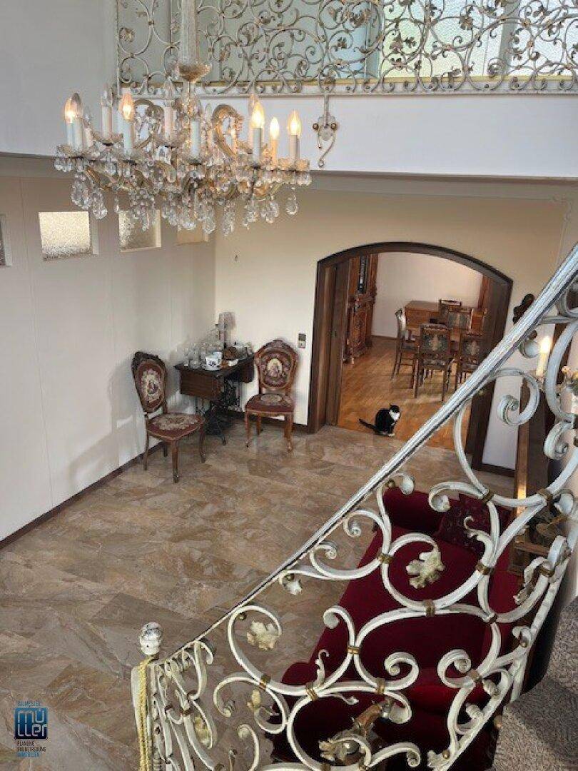 Offener Galeriebereich mit Blick auf die untere Etage, einem eleganten Kronleuchter und Marmorboden.
