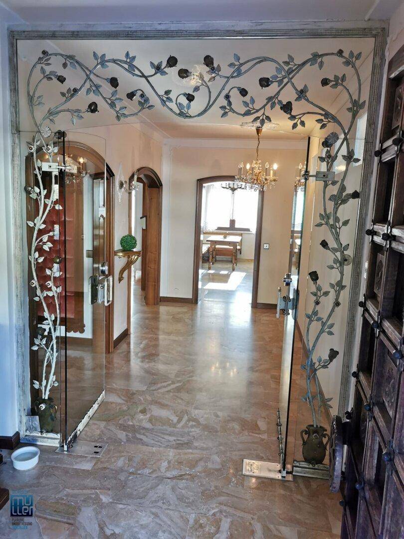 Eleganter Flur mit kunstvoll verzierten Spiegeln, Marmorboden und hohen Decken, der zu weiteren Räumen führt.