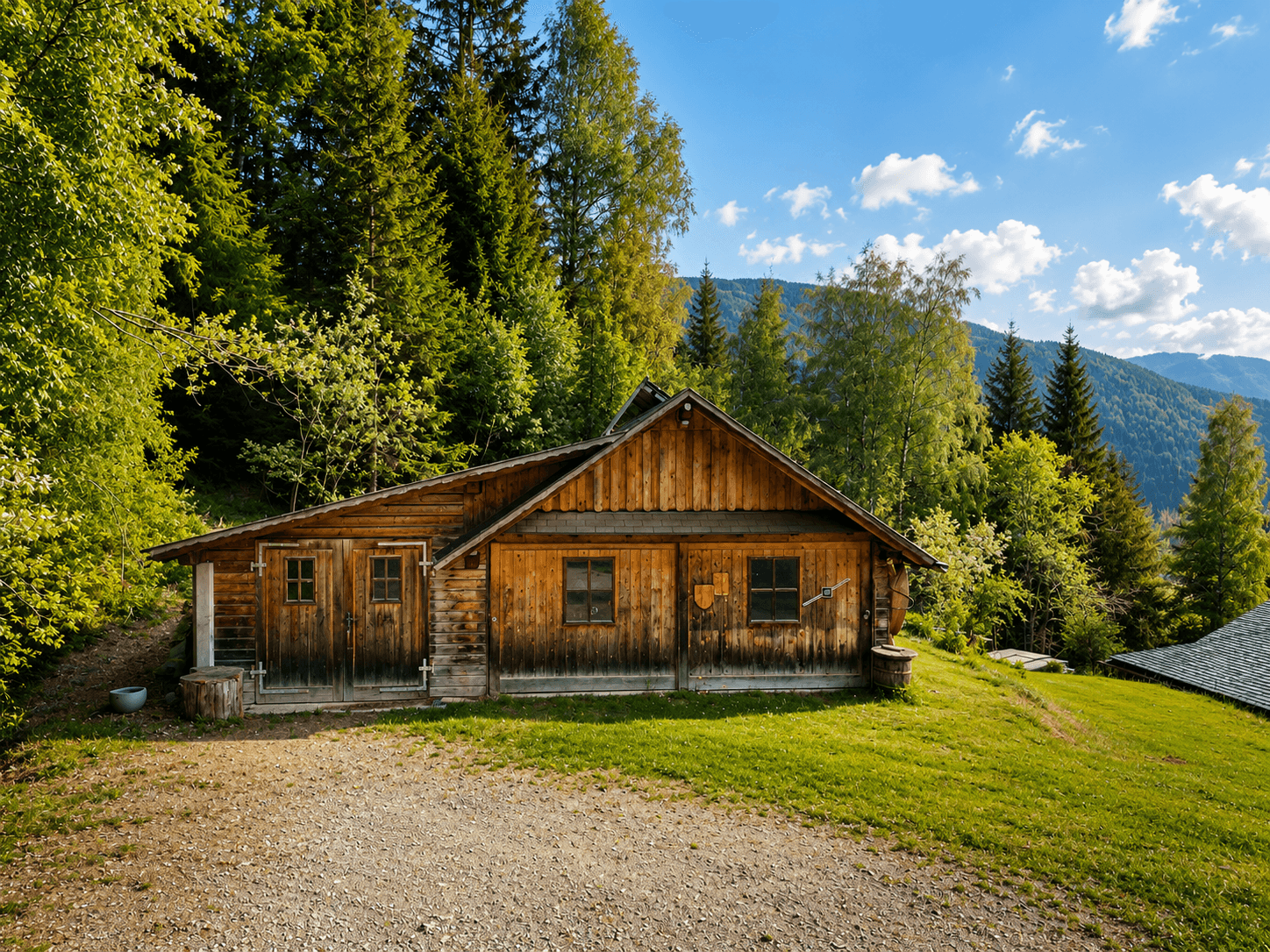 Charmantes Holzhaus im Chalet-Stil, umgeben von grünen Wiesen und Wäldern mit Bergblick.