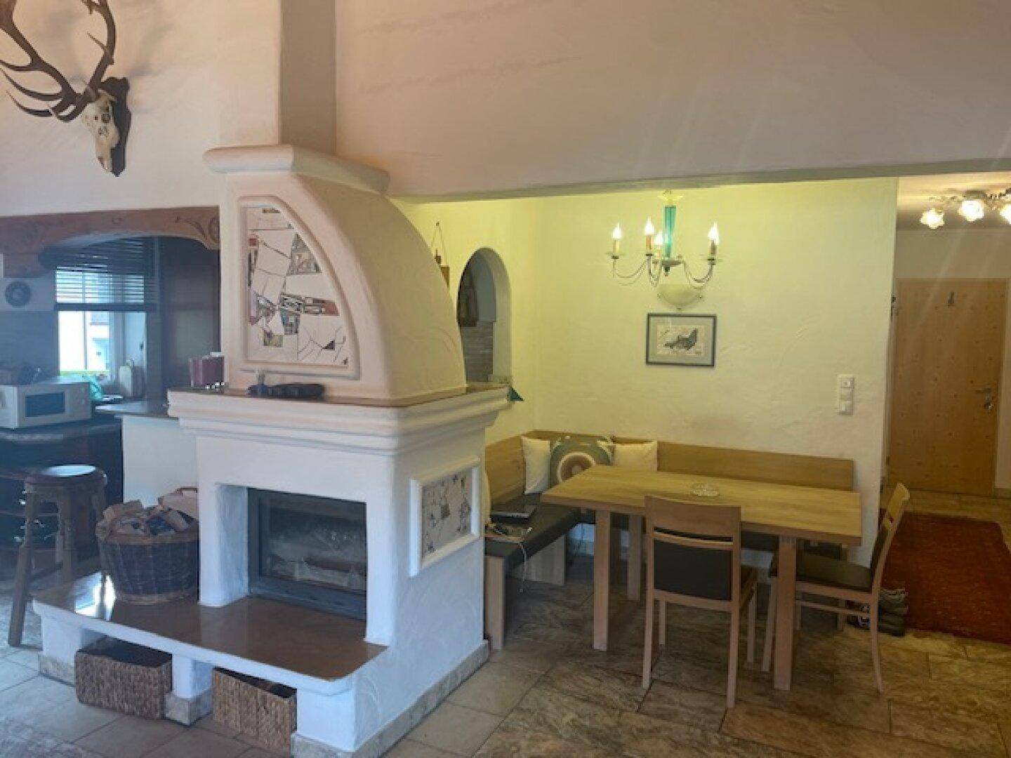 Gemütlicher Essbereich mit Kamin und angrenzender traditioneller Küche.