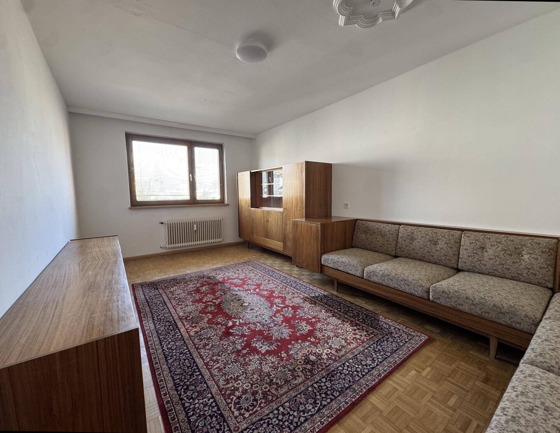 Klassisches Wohnzimmer mit traditionellen Möbeln, großem Orientteppich und charmantem Parkettboden.