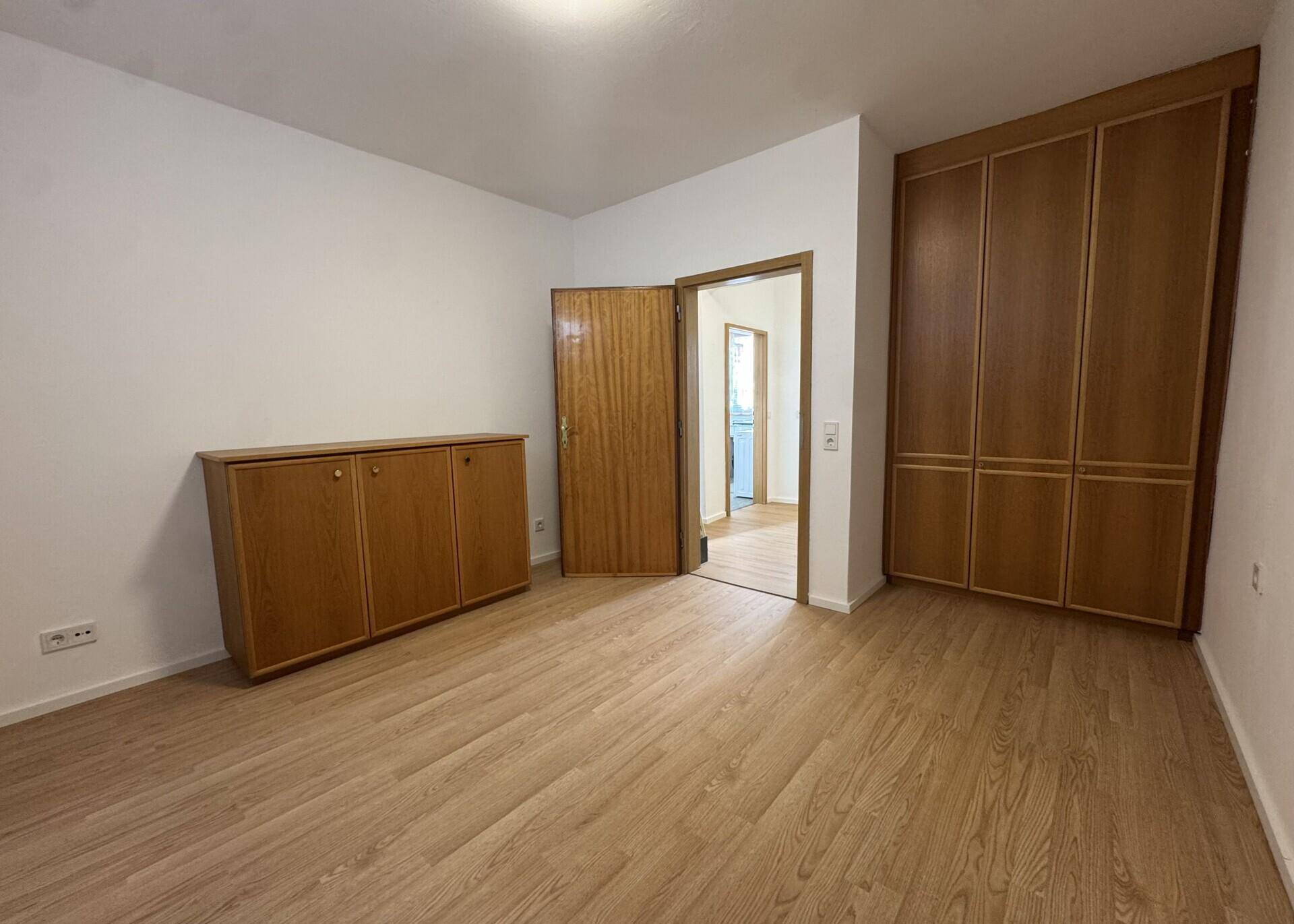 Schlafzimmer mit Einbauschränken und Holzboden, bietet viel Stauraum und eine warme Atmosphäre.