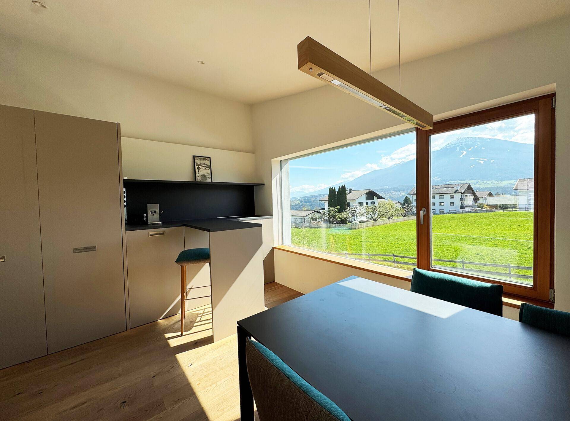 Moderne Küche mit Essbereich und beeindruckendem Blick auf die umliegende Berglandschaft.