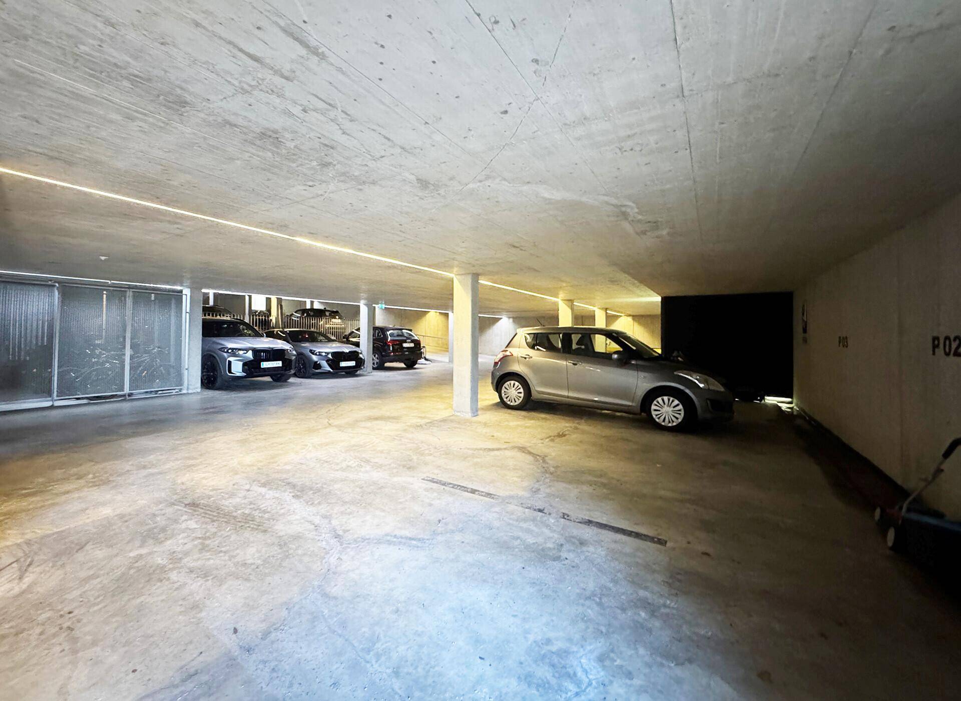 Geräumige Tiefgarage mit mehreren Stellplätzen und Betonboden.