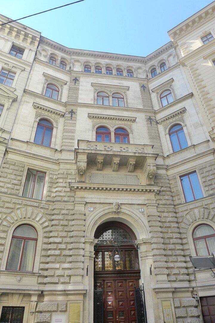 Prächtige historische Fassade eines Gebäudes mit reich verzierten Details und großen Fenstern.