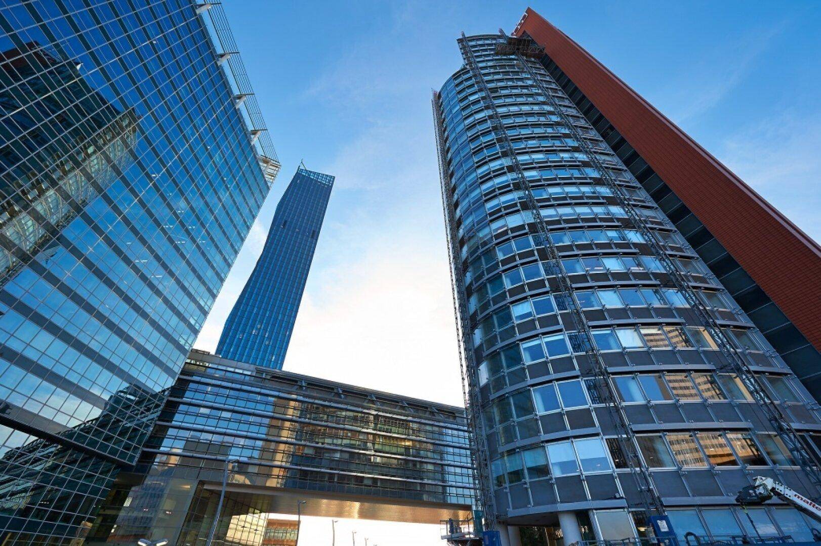 Beeindruckende moderne Hochhäuser mit Glasfassaden unter einem klaren blauen Himmel.