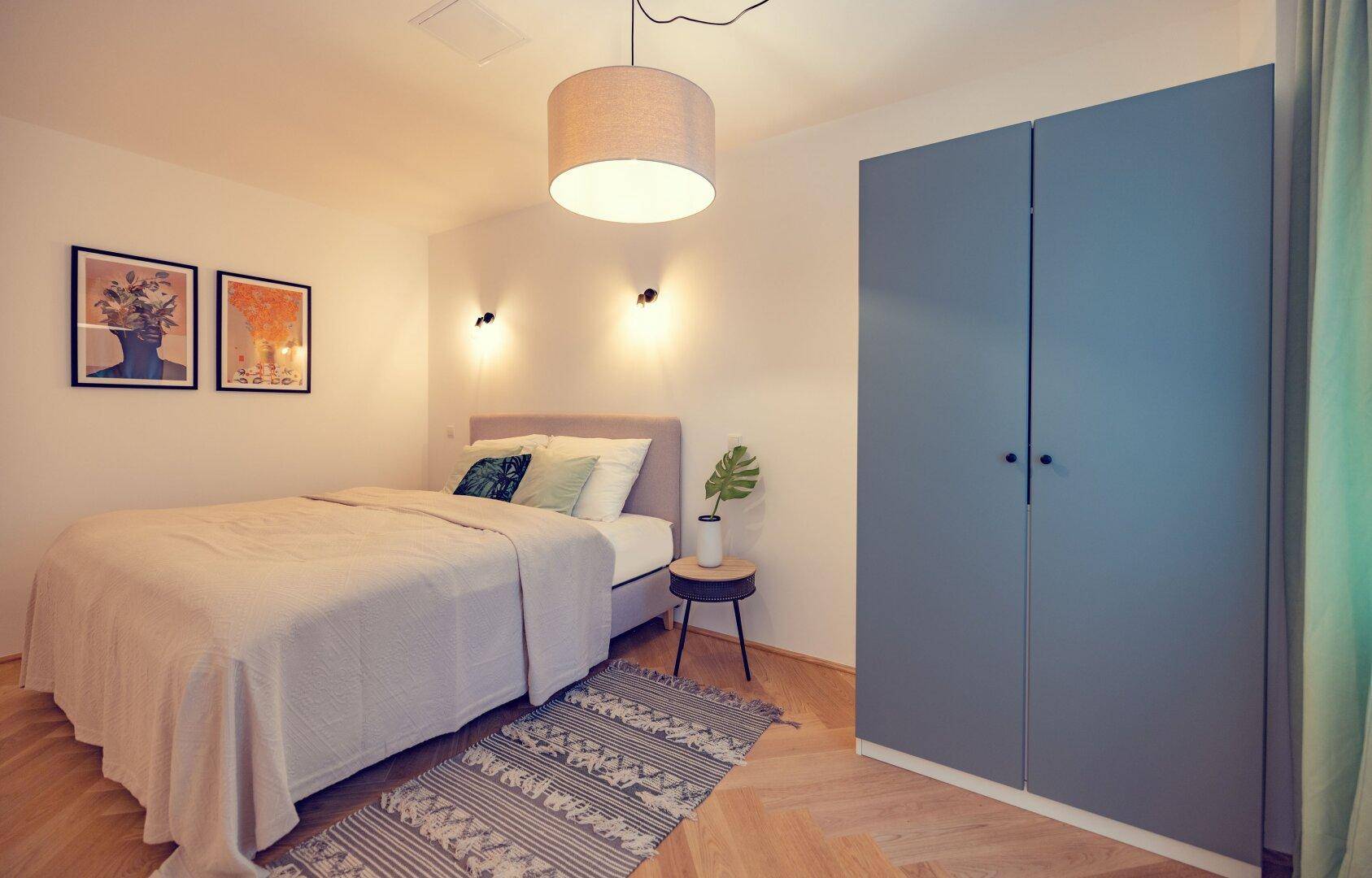 Gemütliches Schlafzimmer mit Doppelbett, modernem Kleiderschrank und Holzboden.