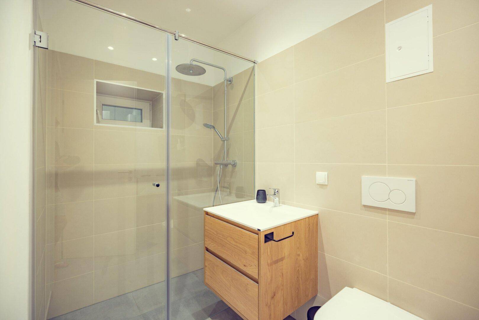 Modernes Badezimmer mit begehbarer Dusche, Einzelwaschbecken und wandhängendem WC.