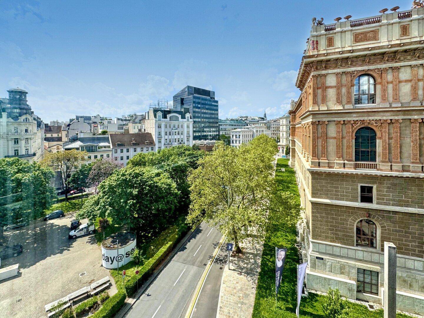 Blick auf eine städtische Umgebung mit Bäumen, Gebäuden und einer Straße, die durch die Stadt führt.