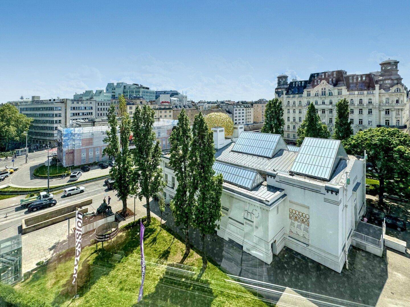 Ansicht eines markanten Gebäudes mit moderner Dachkonstruktion und umliegender Stadtlandschaft.