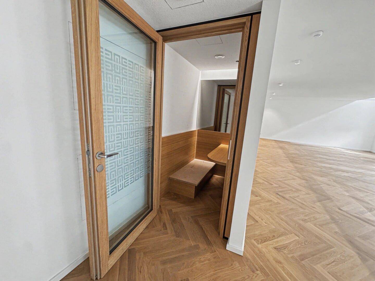 Moderner, schallisolierter Telefonraum oder Besprechungsnische mit Holzelementen und Glasfront.