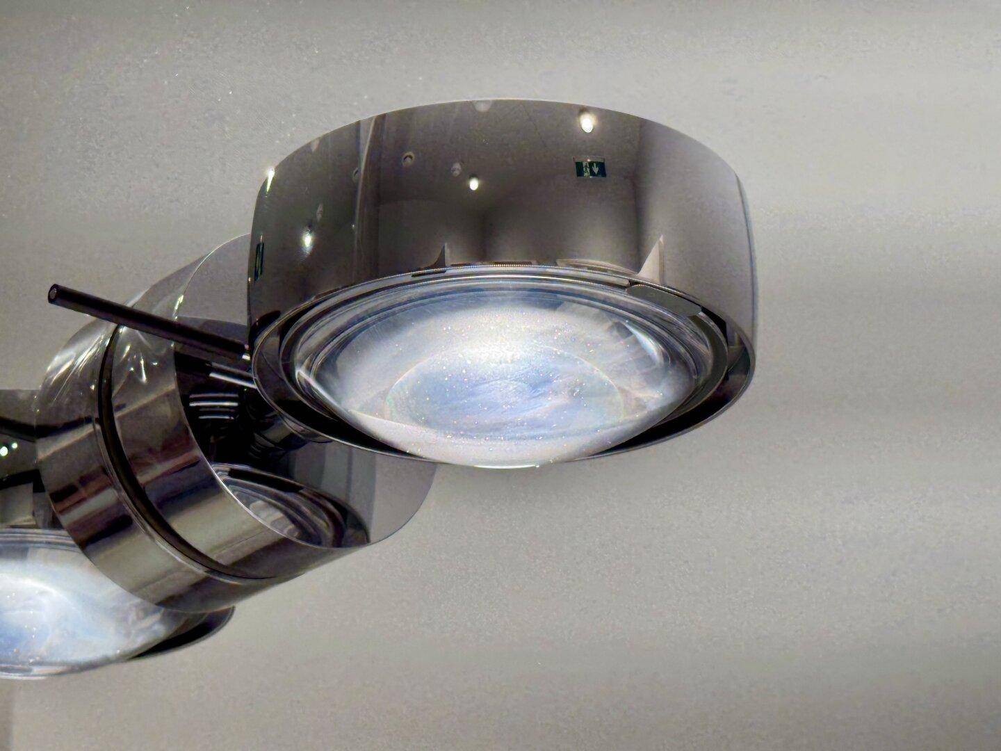 Nahaufnahme einer modernen Deckenleuchte mit Chromdetails und diffusem Licht.