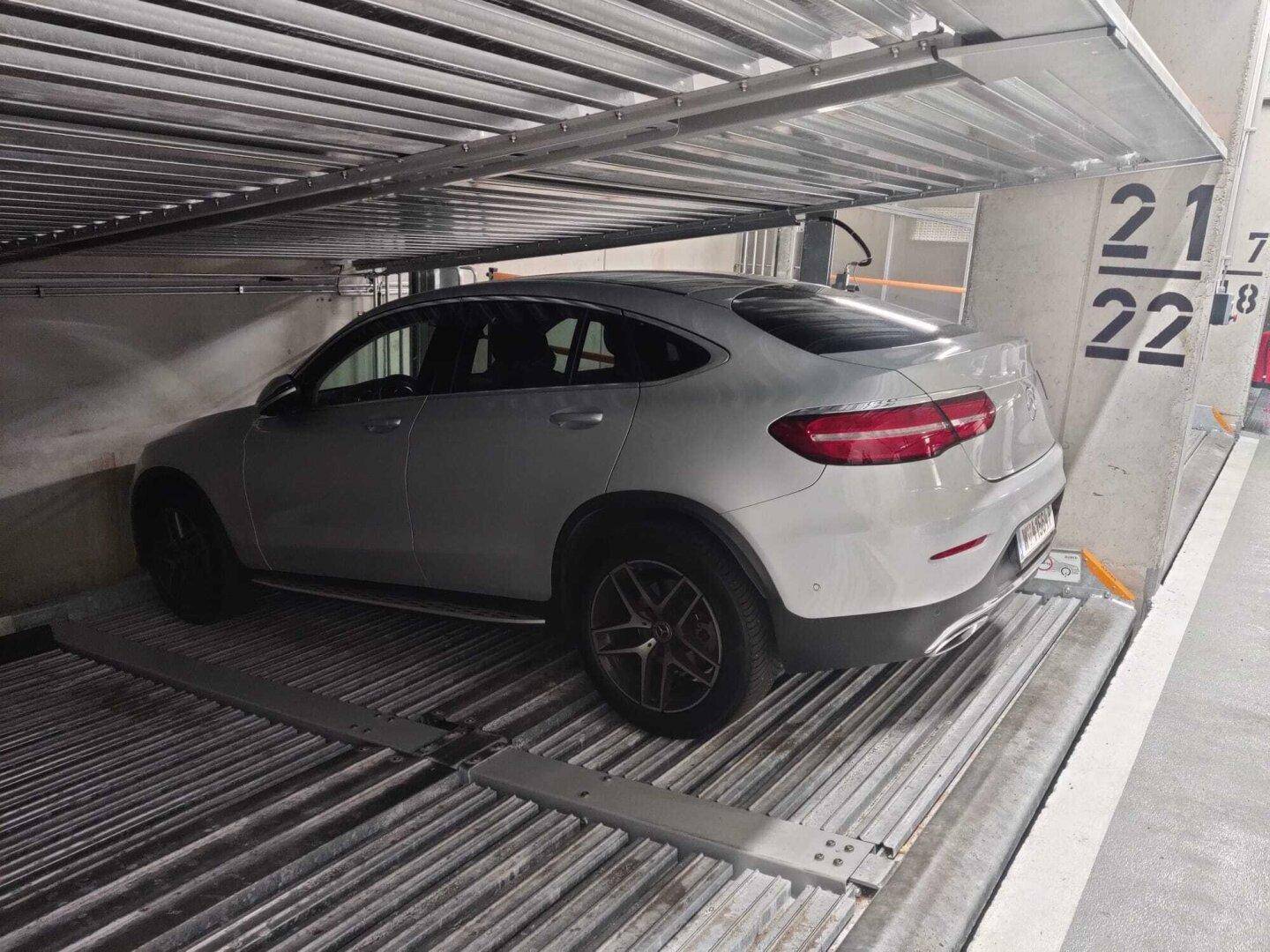 Ein Auto parkt auf einer Plattform eines automatischen Parksystems in einer modernen Tiefgarage.